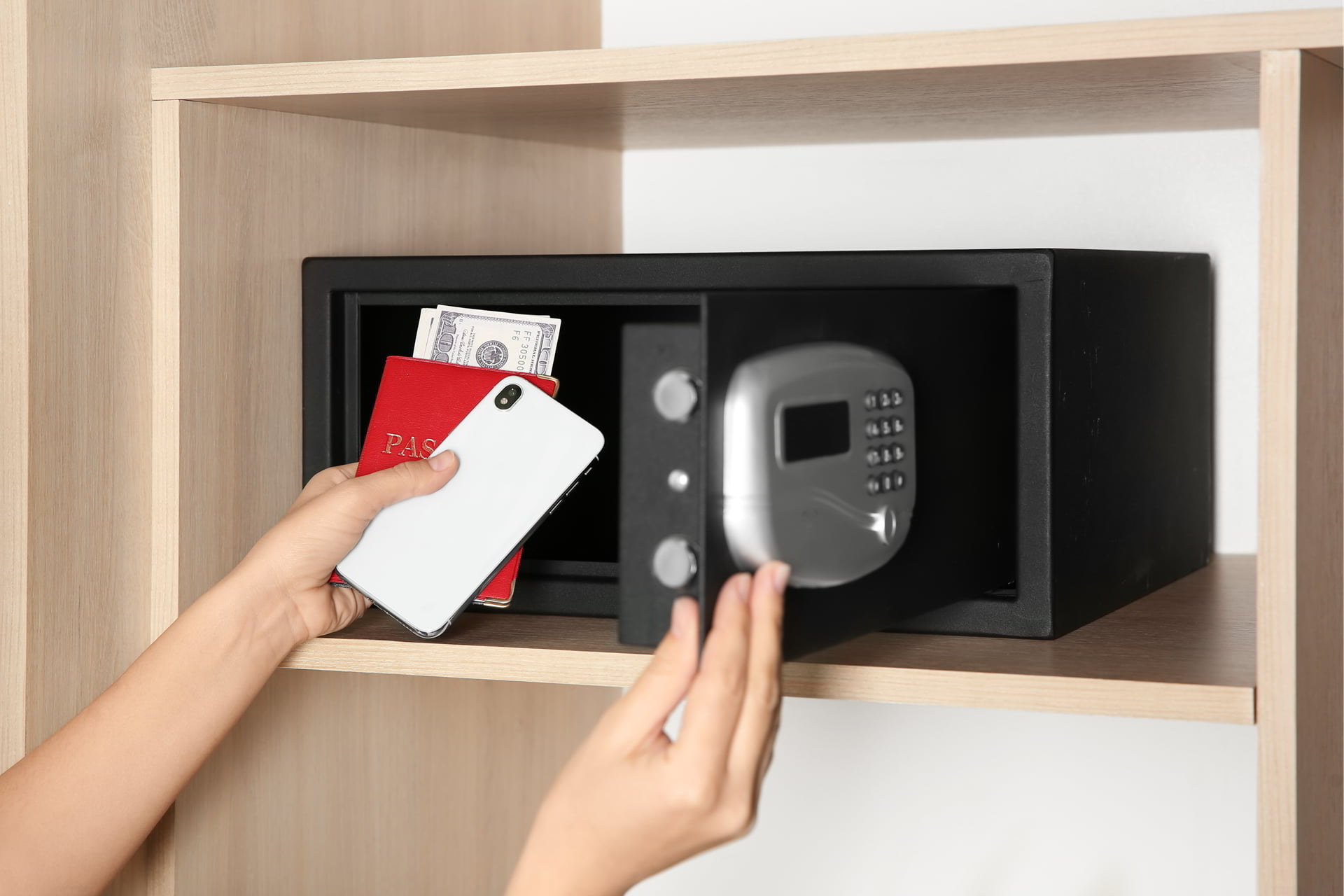 Kvinde lægger mobil og penge i pengeskab